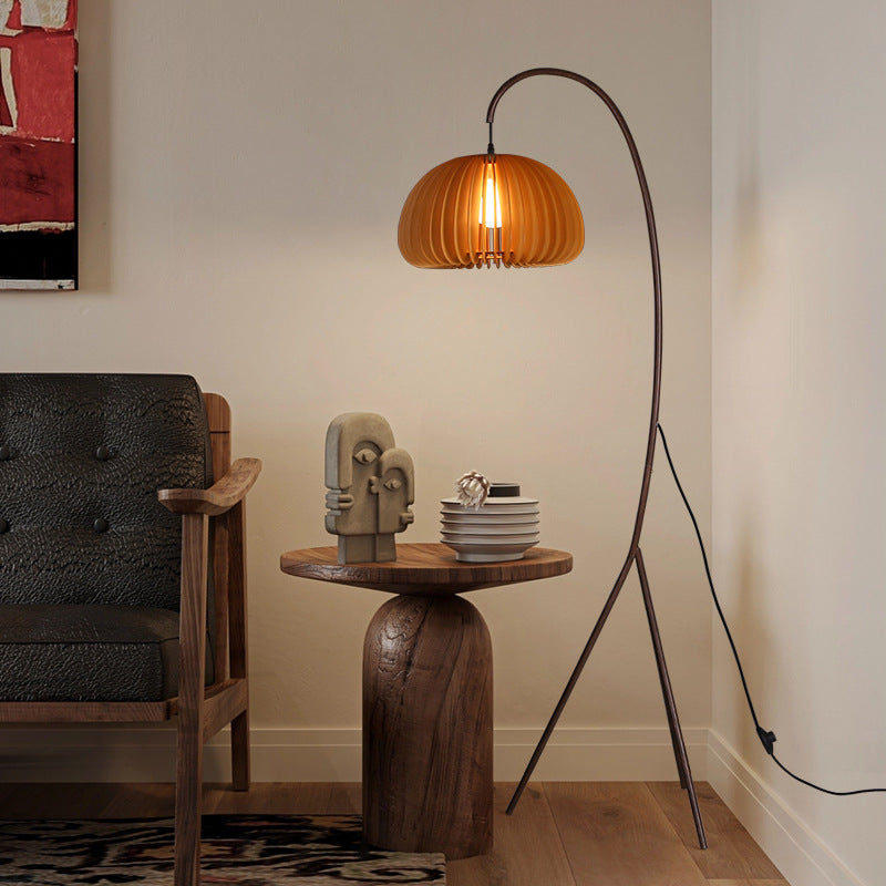 Living room with a floor lamp, side table, and sofa Homezee Modern Japandi WABI SABI Tripod Pumpkin shade in a room with a chair and side table.