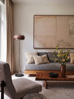 Hand-blown glass floor lamp with amber-pink dome shade and black pedestal base