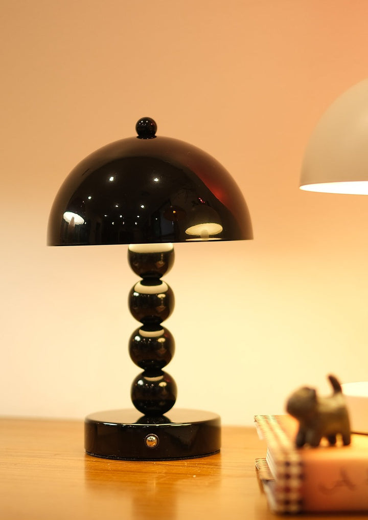 Modern cordless LED lamp casting warm ambient glow on a wooden surface with a blurred background