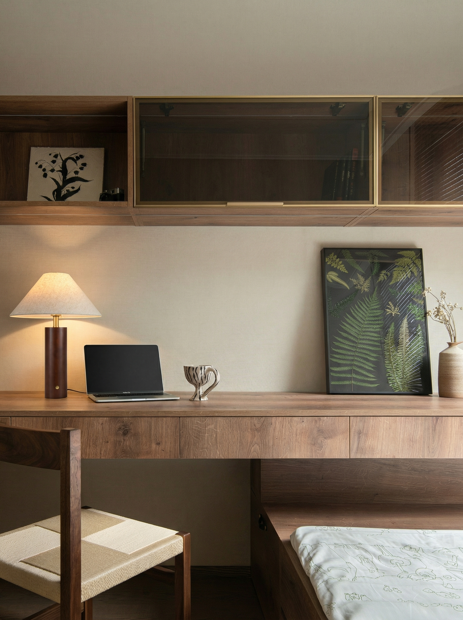 Wooden desk with laptop, lamp, and decorative items in a room.