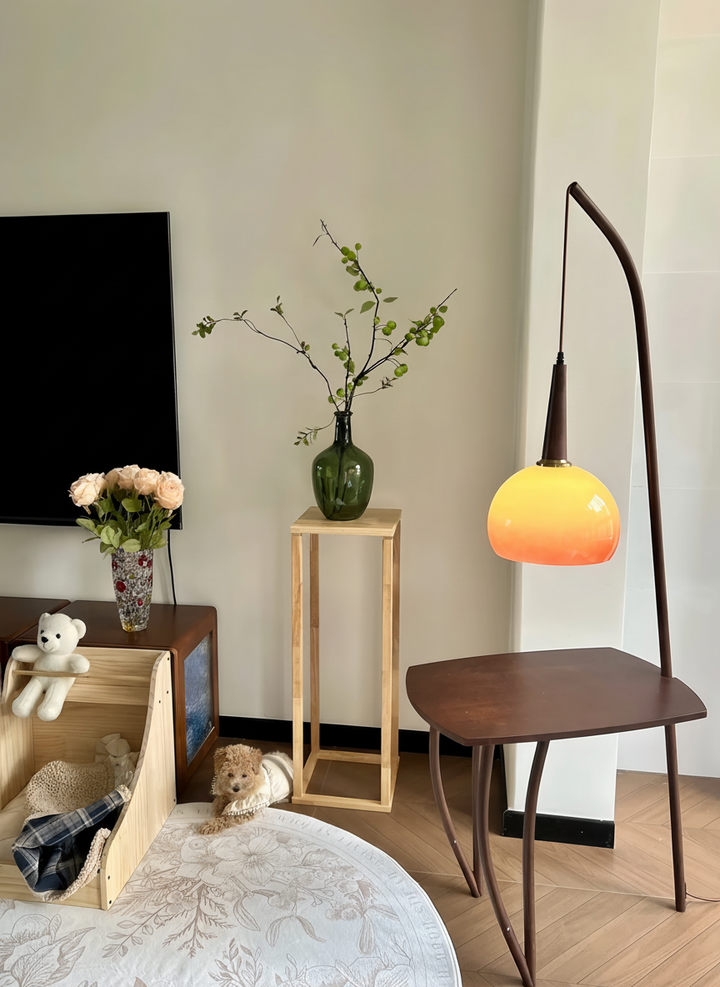 Modern living room with a TV, small table, Domus Pollo Floor Lamp with walnut stand and built-in side table, and decorative items.