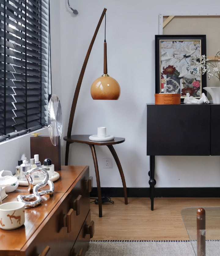 Living room with wooden furniture, Retro floor lamp with glass shade and coffee table storage, and decorative items.
