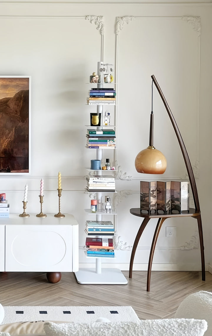 Modern interior with a bookshelf, Mid-century inspired walnut floor lamp with side table, and decorative items.