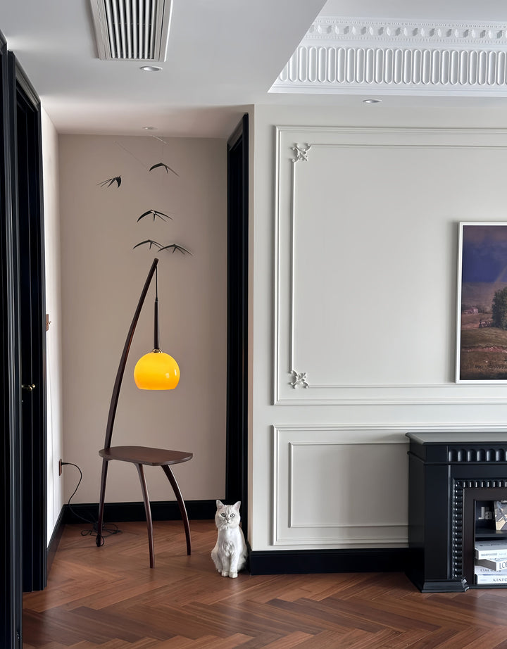 Modern interior with a yellow pendant light,Functional 2-in-1 floor lamp with reading light and table storageblack stool, and white wall.