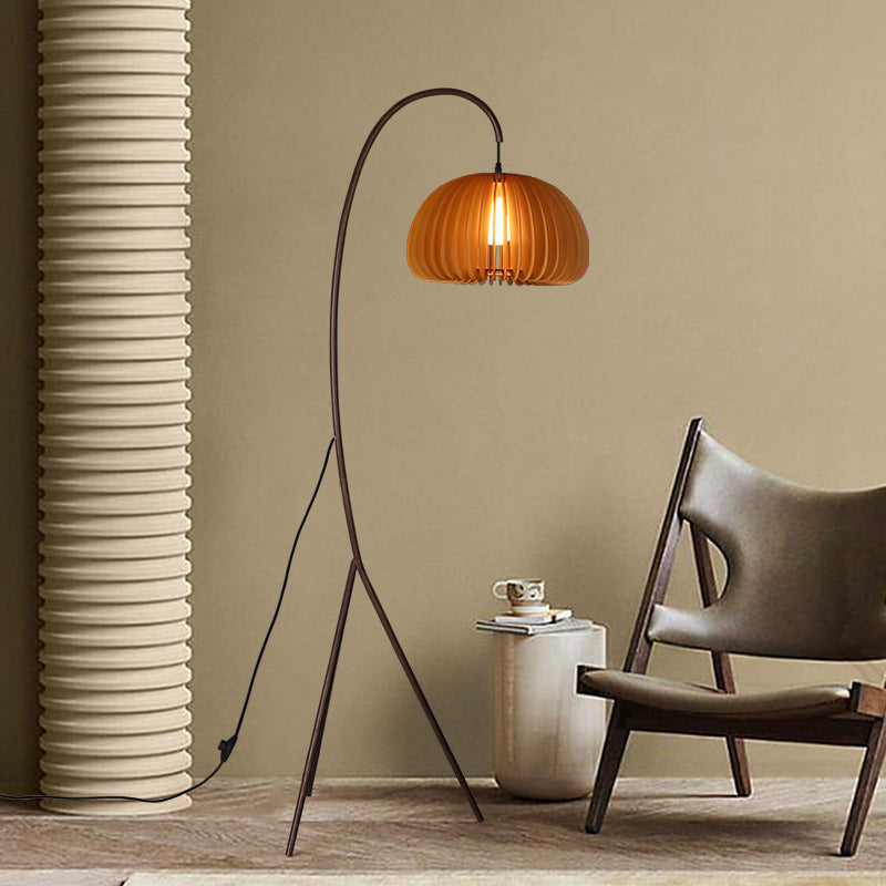 Modern Japandi Tripod Pumpkin shade in a room with a chair and side table.