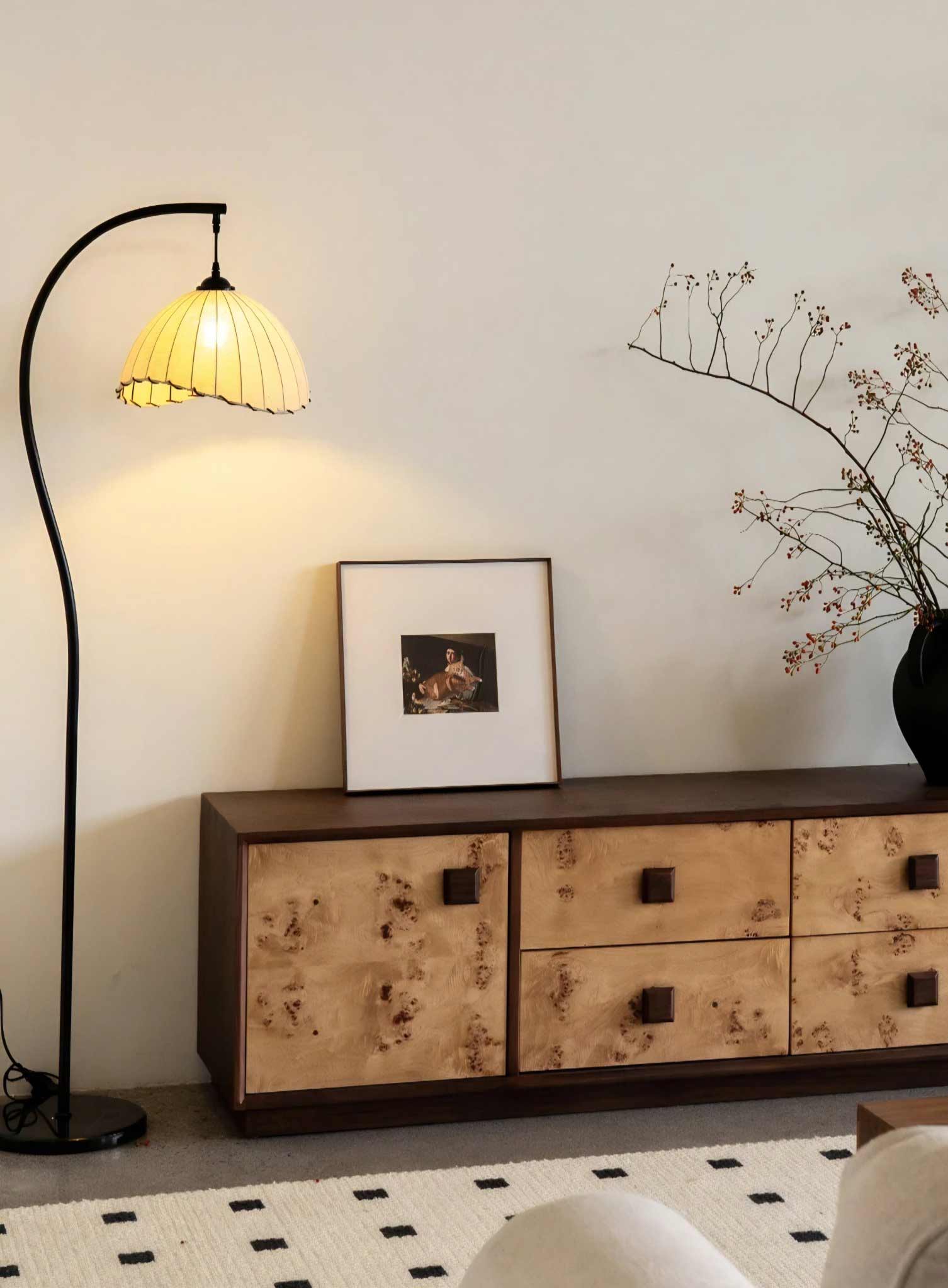 Sideboard with decorative lamp and framed picture in a room setting.