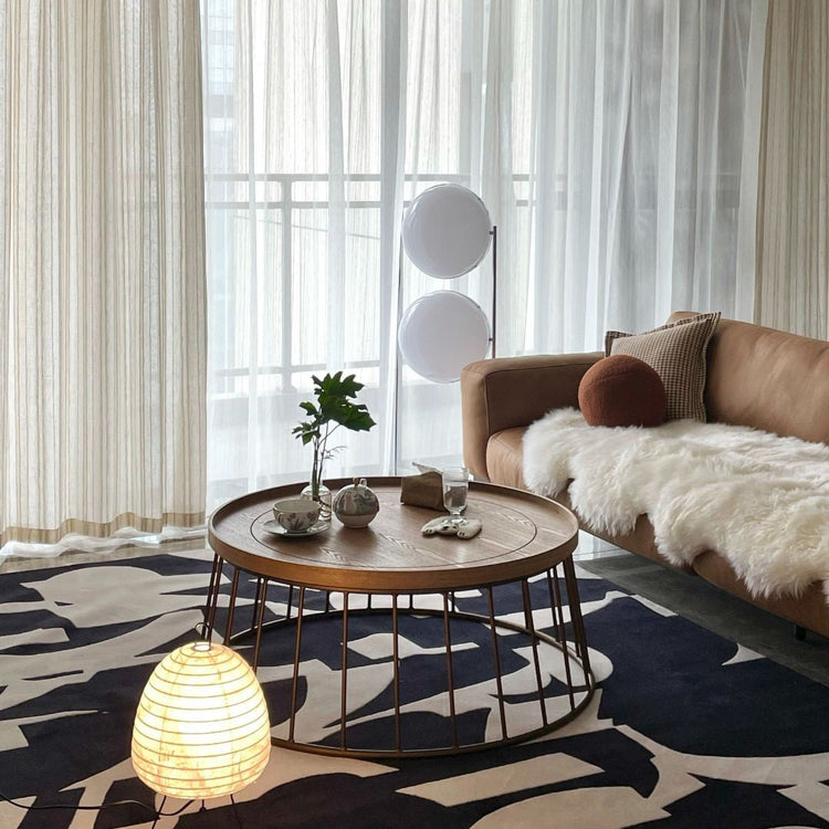 Decorative room setting with a Garreau Globe Floor Lamp Bauhaus Replica Chrome Stand， plants, and a shelf in a warm-toned interior.